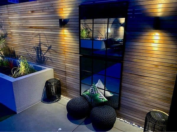 Architectural outdoor wall lighting on timber cladding at dusk