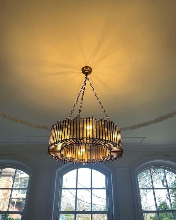 Statement chandelier installed in a period living room with arched windows