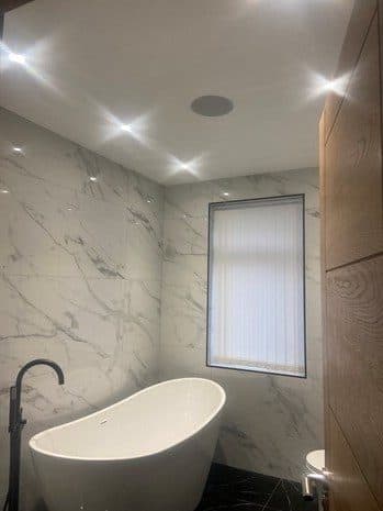 Marble bathroom with freestanding bath and recessed spotlights
